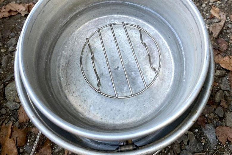 「蒸し器用の外鍋に蒸し網を置き、多めに水を張った」写真